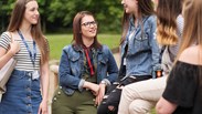 group of female students smiling and talking outside 