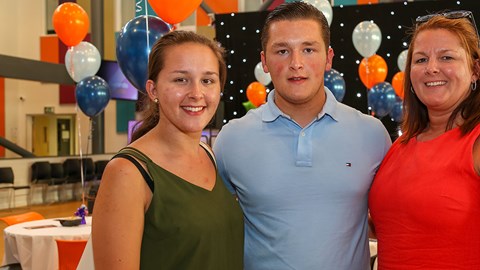 Male student with sister and mum either side at student awards