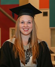 Higher Education student Holly Archer at Graduation wearing robe and hat