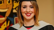 Higher Education student Sophie Hadkiss wearing graduation robe and hat