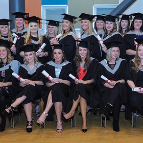 Higher Education students photographed in two lines at graduation after graduating