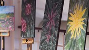 Art students work displayed - three separate paintings of flowers