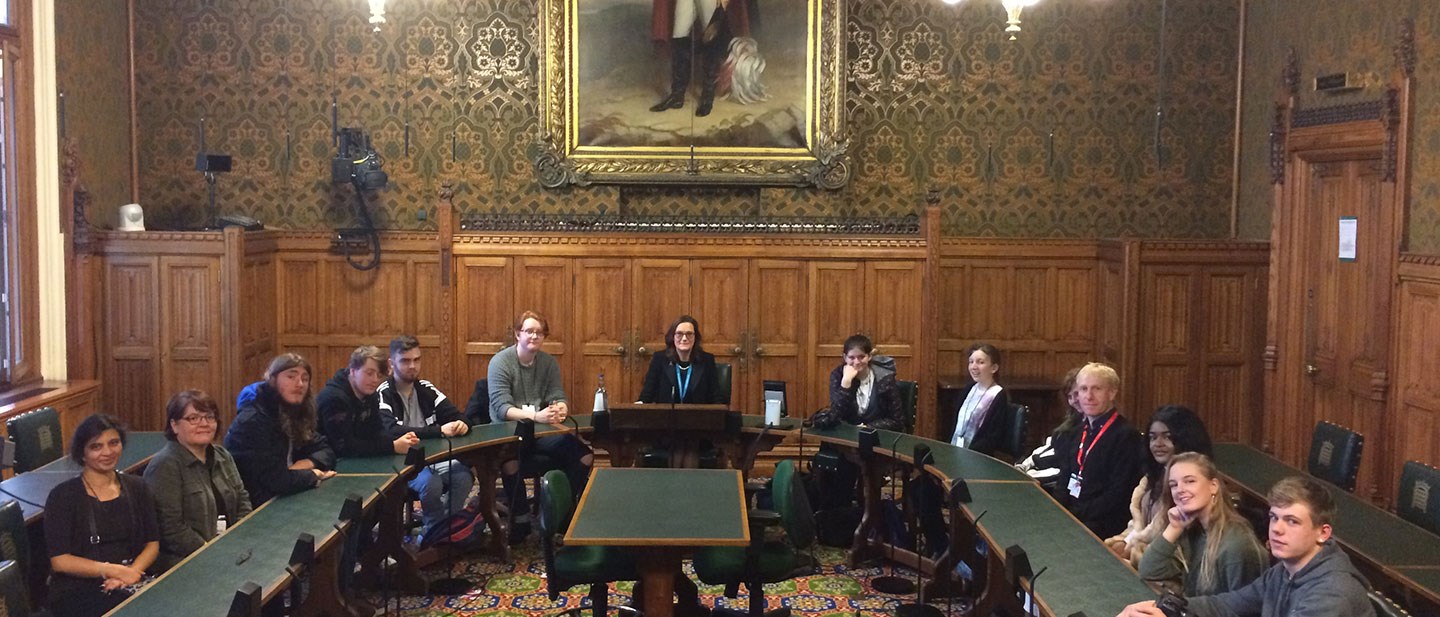 Politics students sitting around a large table at the House of Commons with MP Rebecca Harris
