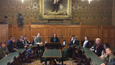 Politics students sitting around a large table at the House of Commons with MP Rebecca Harris