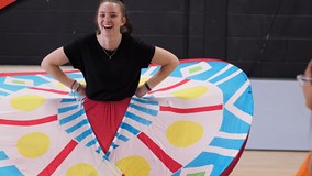 performing arts student rehearsing for upcoming show with butterfly wings as a prop