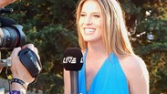 female news reporter doing a live stream outside with cameras and a microphone