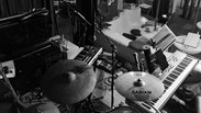 Music studio filled with drums, piano and a guitar