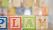 children building blocks spelling the word play