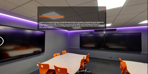 5 screens across 4 walls in a grey room with mood lighting and moveable desks and chairs.