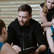 A male  Sports coach with female students.