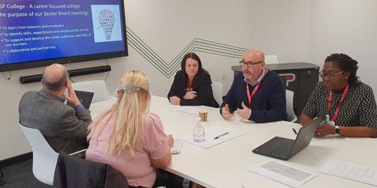 A meeting of adult teachers in a boardroom.