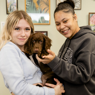 Two students holding a puppy.