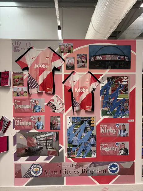 A colourful football themed display on a wall at an exhibition, featuring a football shirt designed by a student for the Women's FA Cup Final.