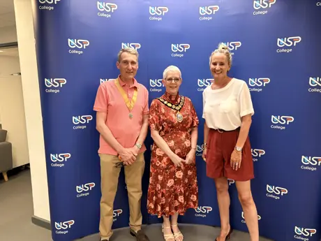 Two women and a man smiling at the camera