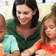 A female student wearing green shirt with three young children.