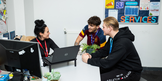 A support staff member helping students.